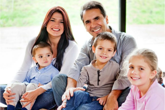 A blended family is happy smiling at the camera after counseling for step parents in Forest Hills, NY with Deborah Karnbad, Marriage Counselor in New York, New York. You can get help for your blended family here! Online therapy in New York too.