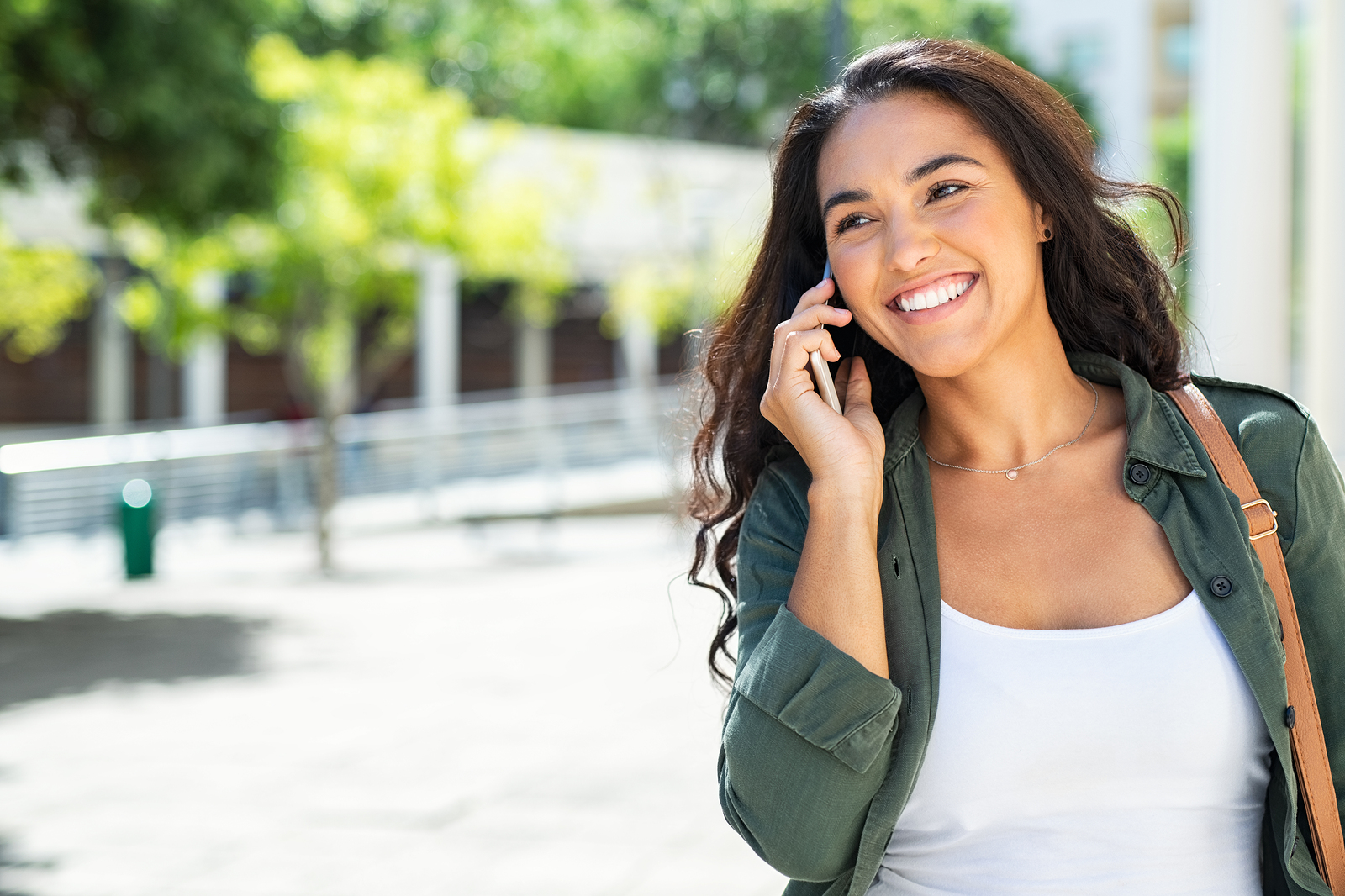 A girl smiles while talking on the on the phone. She is happy with her decision to begin trauma therapy in Forest Hills, NY with trauma therapist Deborah Karnbad.