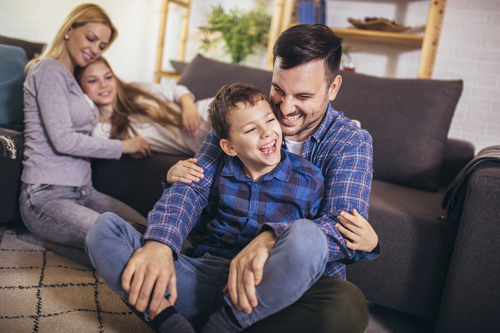 A family laughs and smiles together. They are feeling much happier after they have started counseling for step parents in Forest Hills, New York with family therapist Deborah Karnbad.