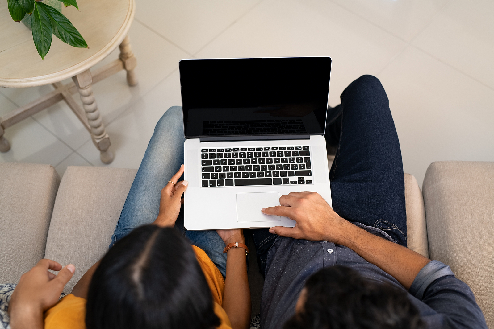 A couple uses a laptop. Their online session for counseling for stress in New York is about to begin with Deborah Karnbad.