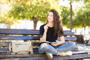 A girl sits on a bench. She is excited to start anxiety therapy in Forest Hills, NY with Deborah Karnbad. 