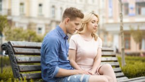A couple sits next to each other on a bench. They are looking forward to starting premarital counseling in Long Island, NY with Deborah Karnbad. 