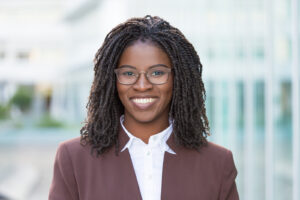 A woman smiles in front of a blank background. She is feeling happy since starting depression counseling in Long Island, NY with Deborah Karnbad.