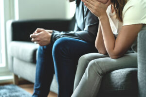 A couple sits next to each other. They are looking forward to starting online marriage counseling in Forest Hills, NY with Deborah Karnbad doing online therapy in New York 11375