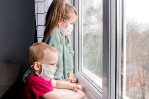 Two kids look out the window. This reflects concepts of parent counseling in Forest Hills, NY via online therapy in new york with a NY online therapist.